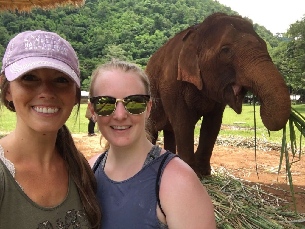 us hanging out with an elephant at the Elephant Nature Park in Thailand