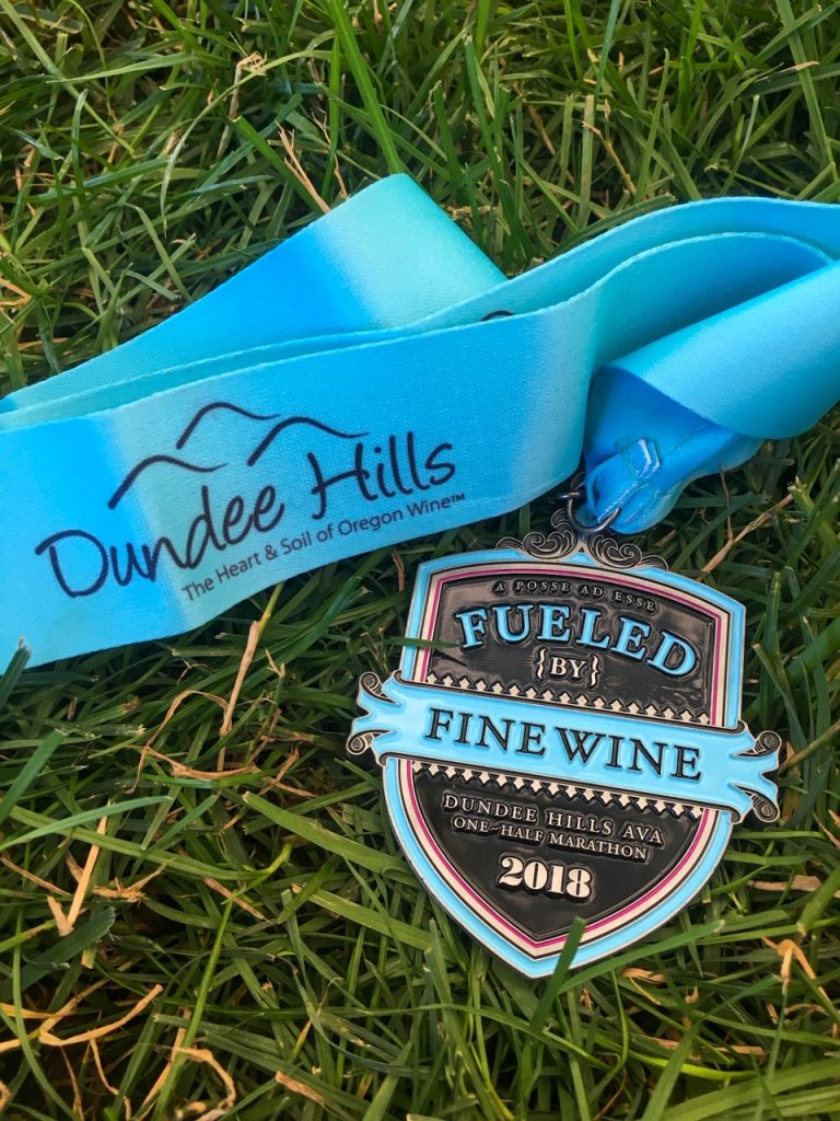 our finisher medal from the Fueled by Fine Wine Half Marathon in Dundee Hills, Oregon