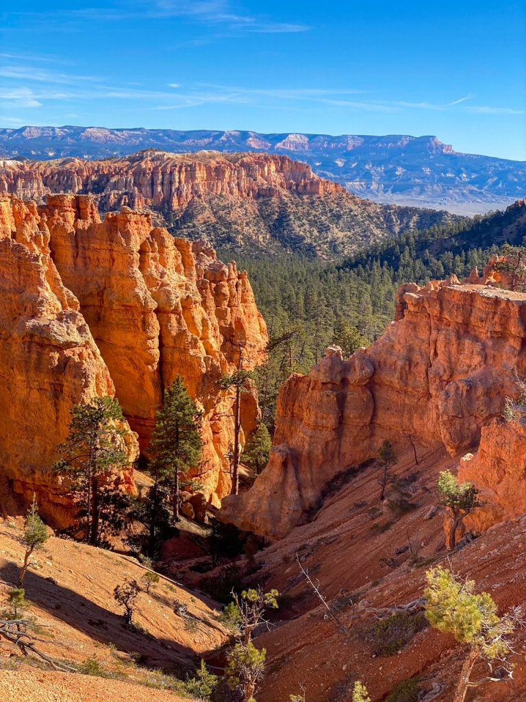 a canyon and hoodoo view with mountains in the background along the Peekaboo Loop in Bryce