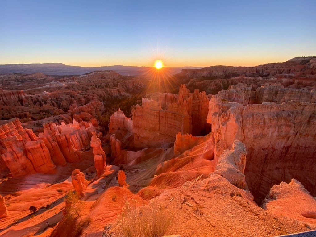 the hoodoos turning bright orange and red at sunrise at Sunset Point in Bryce Canyon