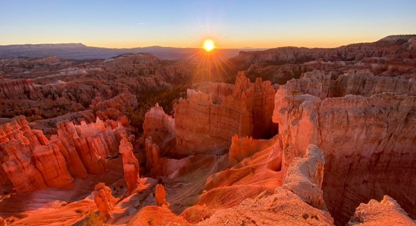 the hoodoos turning bright orange and red at sunrise at Sunset Point in Bryce Canyon National Park