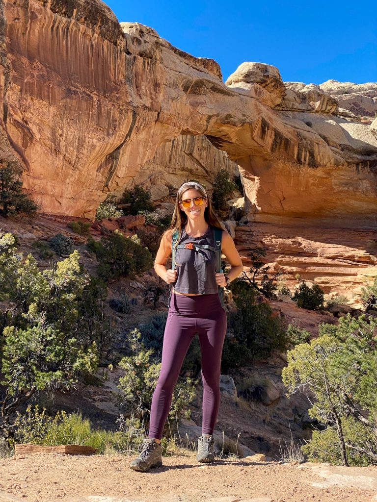 Sara posing with all of her hiking gear in front of the Hickman Bridge in Capitol Reef National Park