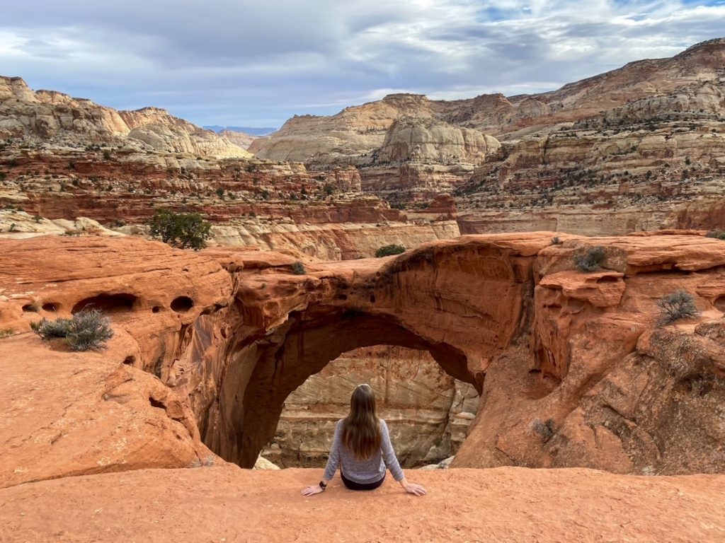 Sara sitting in front of the iconic Cassidy Arch, the first hike of our one day in Capitol Reef National Park