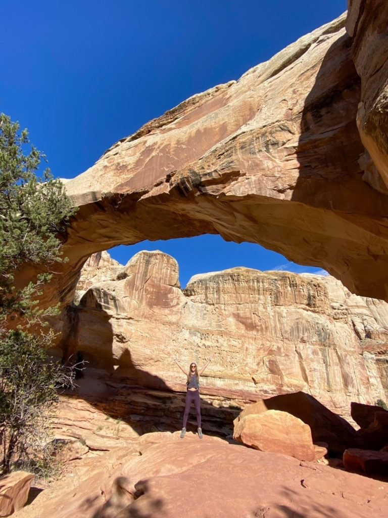 Sara with her hands up in the air at Hickman Bridge in Capitol Reef