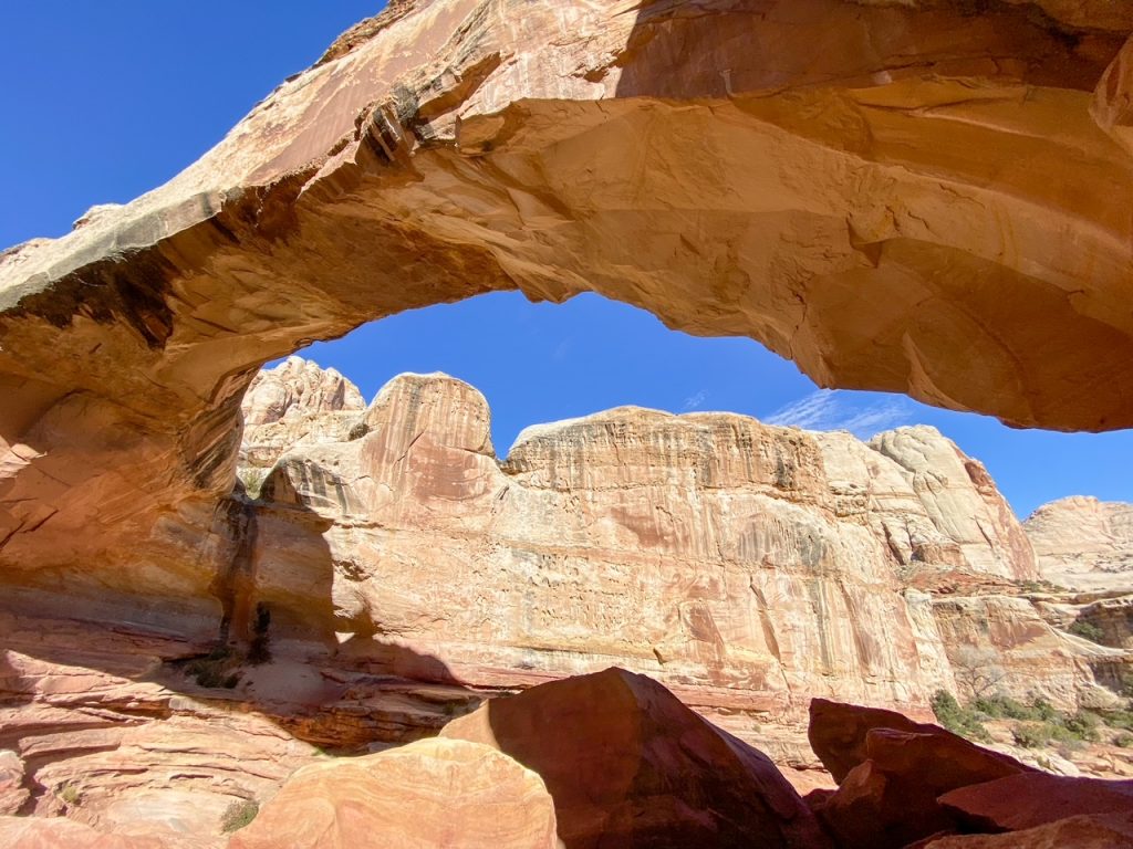 a framed view of a massive rock formation behind the Hickman Bridge at Capitol Reef