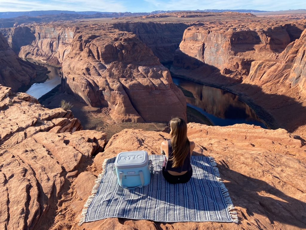 Sara with some add-ons from this hiking packing list at Horseshoe Bend near Page, Arizona