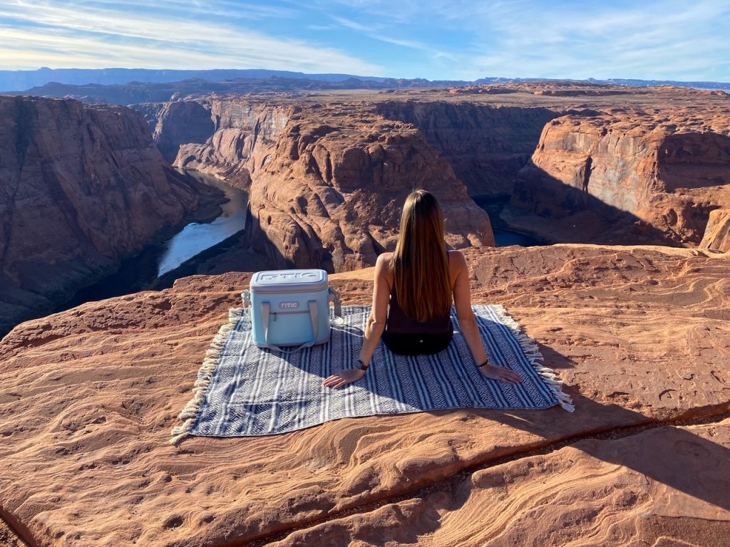Sara with her blanket and cooler having a picnic at Horseshoe Bend in Page in the afternoon