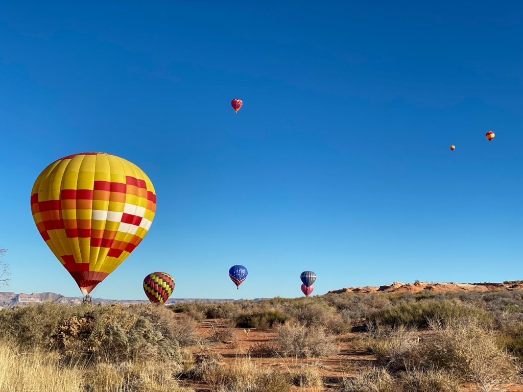 several balloons taking flight one morning during the Lake Powell Balloon Regatta in Page, AZ