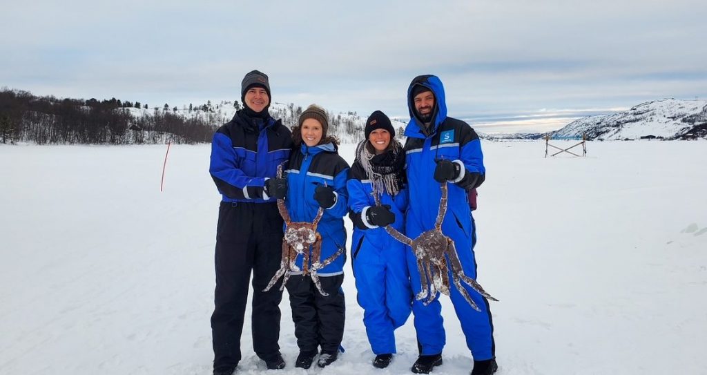 two couples holding their King crabs on a King Crab Safari through the Snowhotel Kirkenes