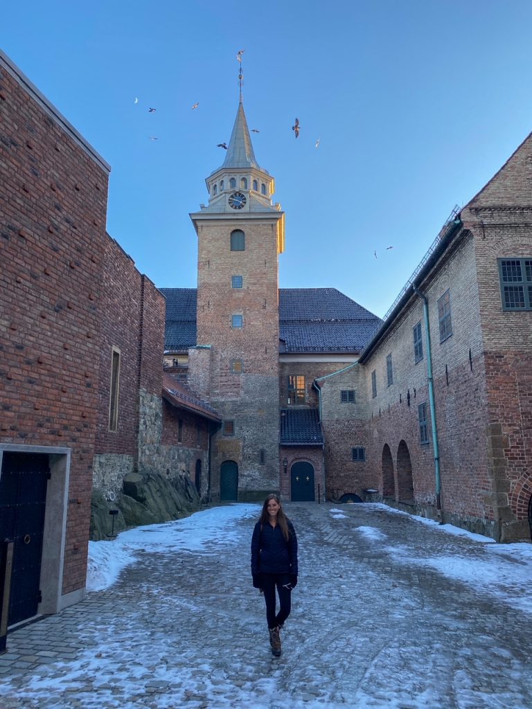 Sara bundled up in her winter gear outside Akershus Fortress on a snowy day in Oslo