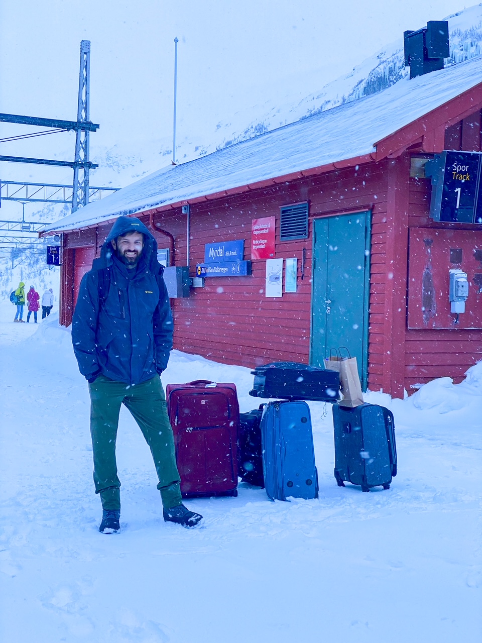 Tim standing with our luggage in the snow in Myrdal, Norway