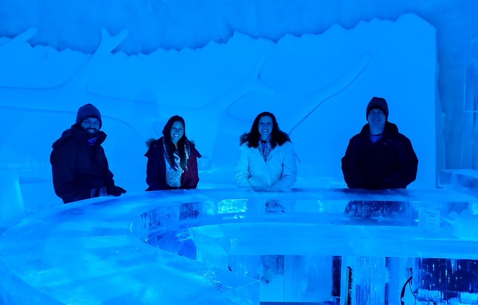 a group of friends sitting at an empty ice bar at the Snow Resort Kirkenes back in 2022