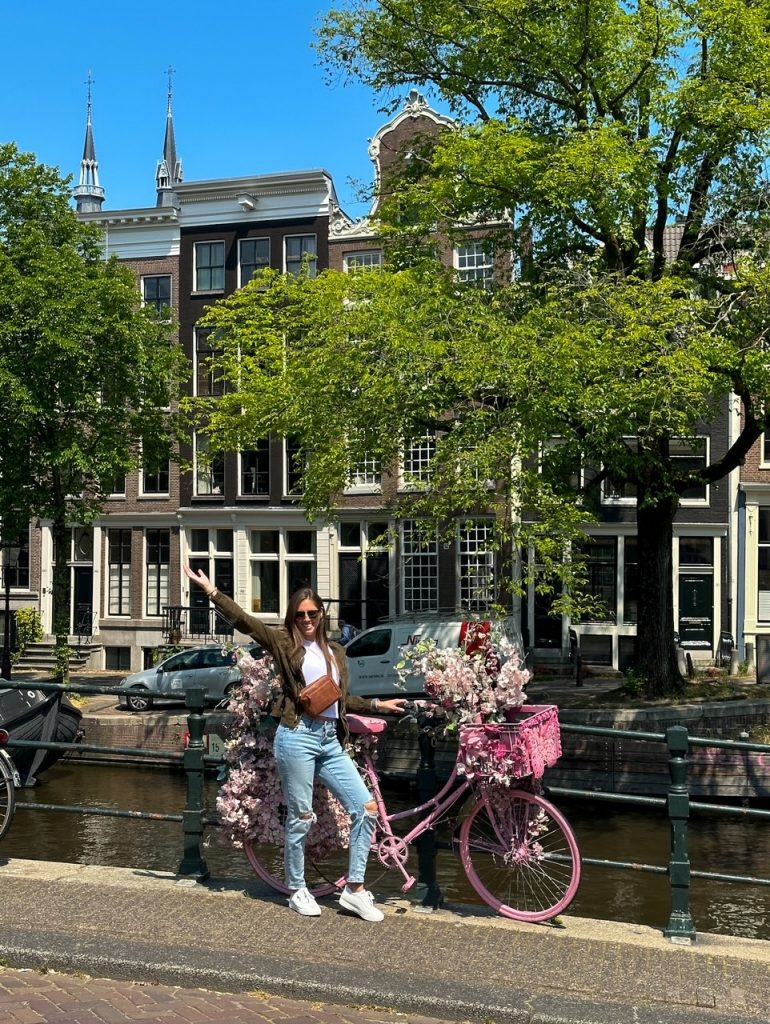 Sara posing with a bike in Amsterdam in the spring