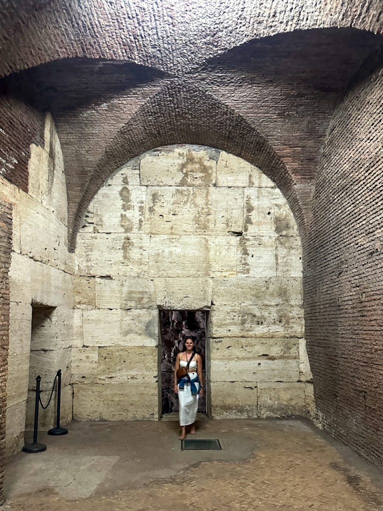 Sara standing in the underground area of the Colosseum