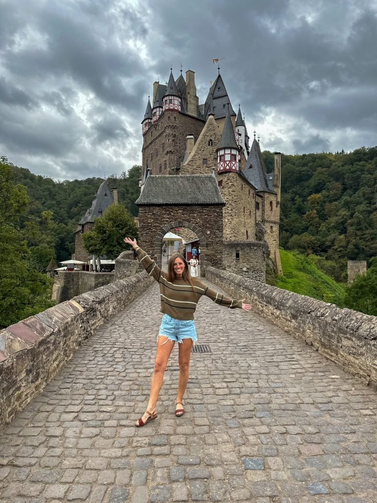 Sara of Travel A-Broads posing in front of Eltz Castle in the Moselle Valley