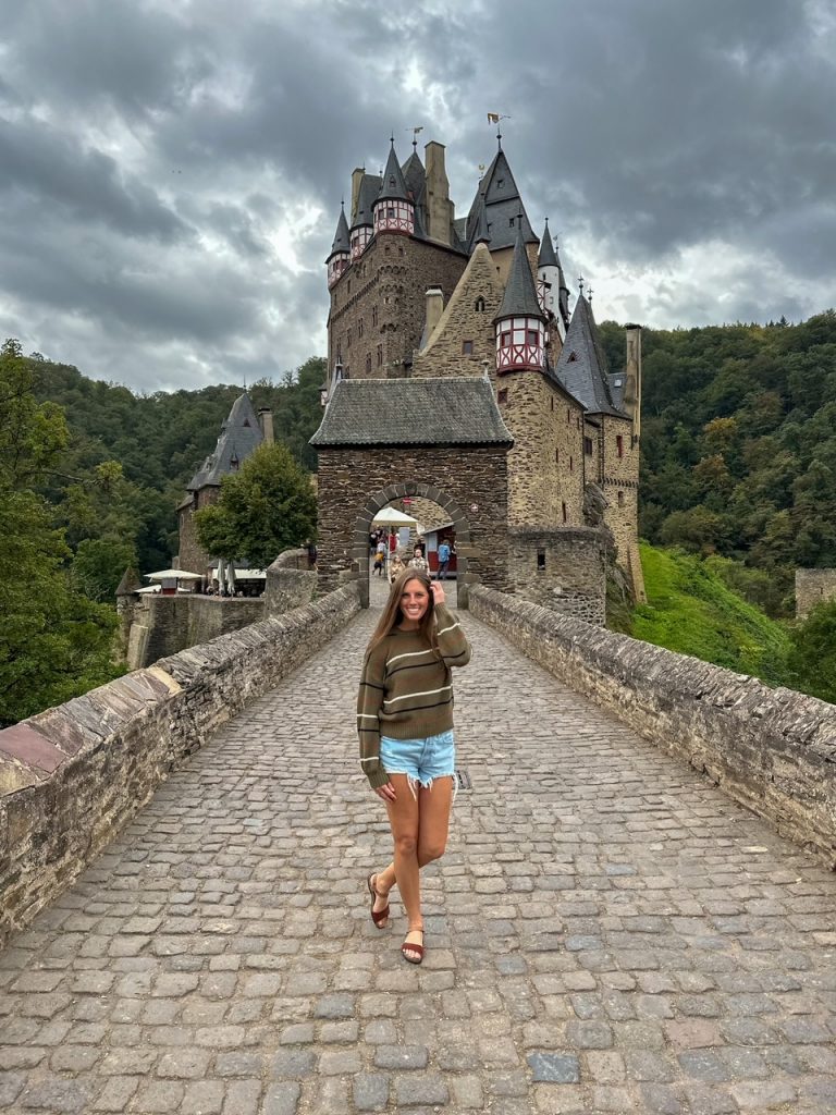 Sara posing in front of Burg Eltz, one of the best day trips from Frankfurt