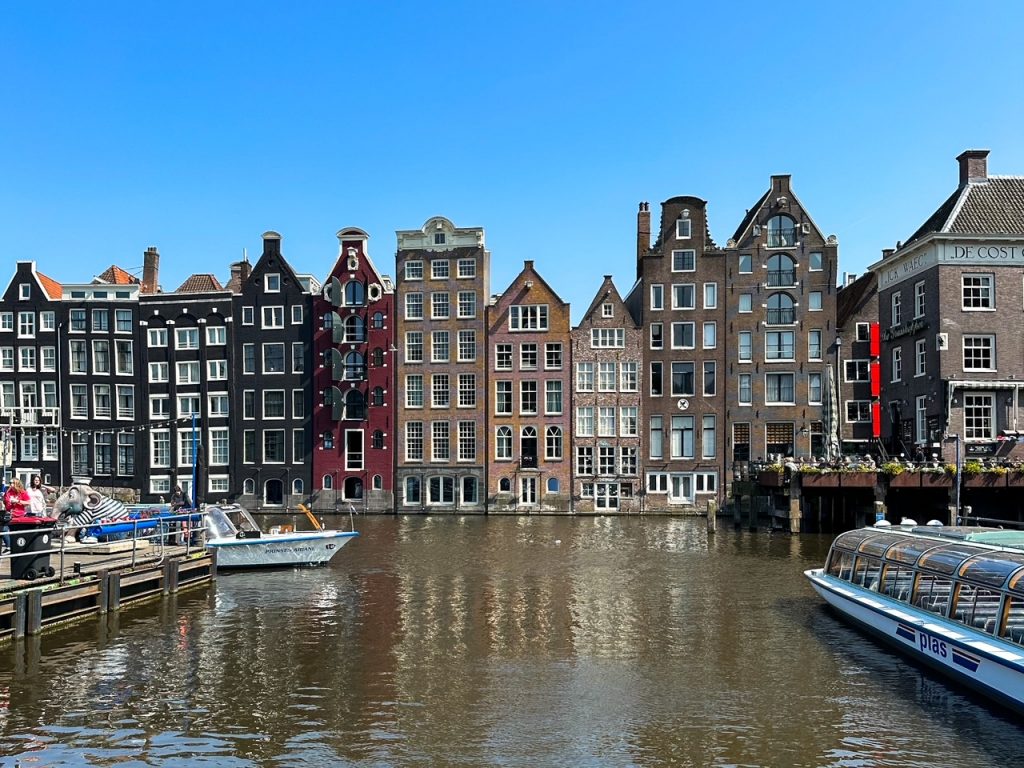 Damrak, a popular area in Amsterdam, the Netherlands, a great place to begin your 2-week summer Europe itinerary