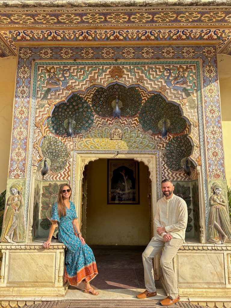 Sara & Tim in front of the peacock gate at the City Palace in Jaipur