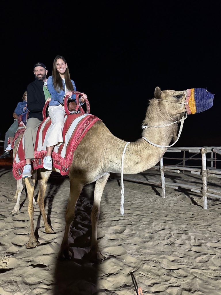 Tim & Sara riding a camel in the Dubai Desert