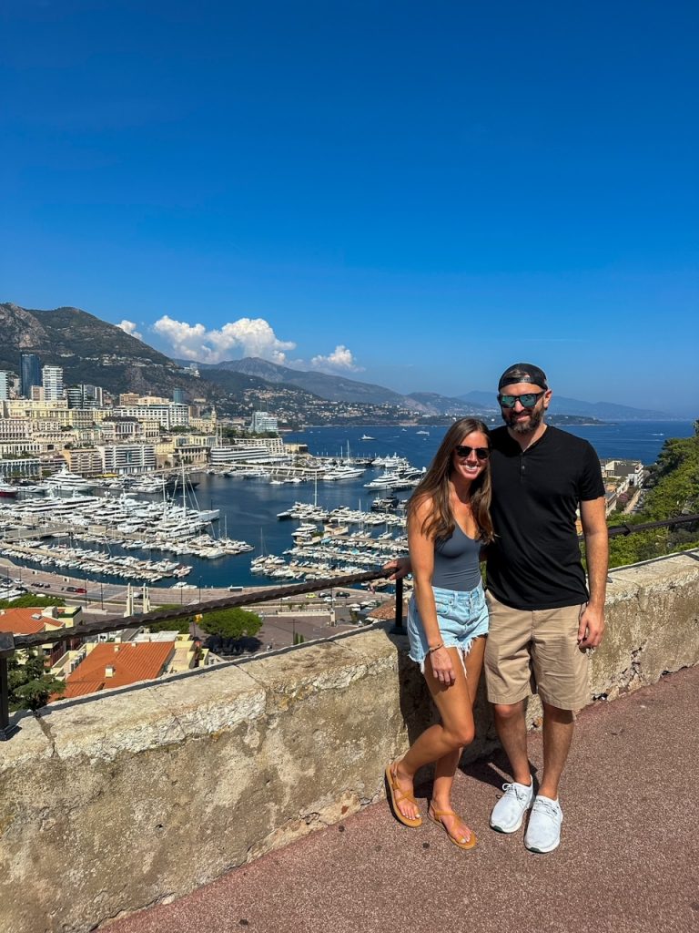 Sara & Tim in front of the panoramic view from the Place du Palais