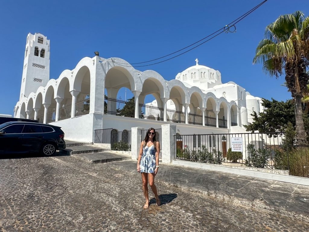 Sara in front of a white church in Fira