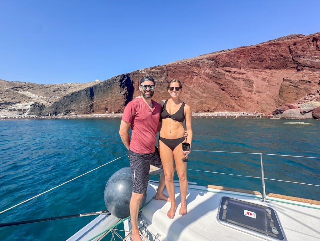 Tim & Sara sailing around on a catamaran, one of the best things to do in Santorini
