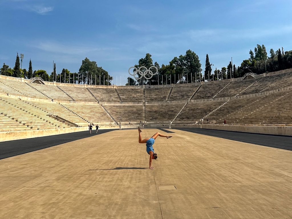 Sara doing a handstand at the Panathenaic Stadium, one of the best things to do in Athens