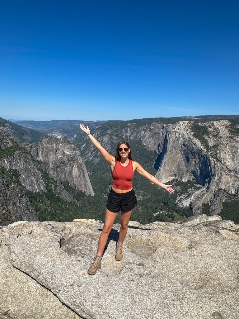 Sara posing in front of El Capitan and Yosemite Valley at Taft Point in Yosemite