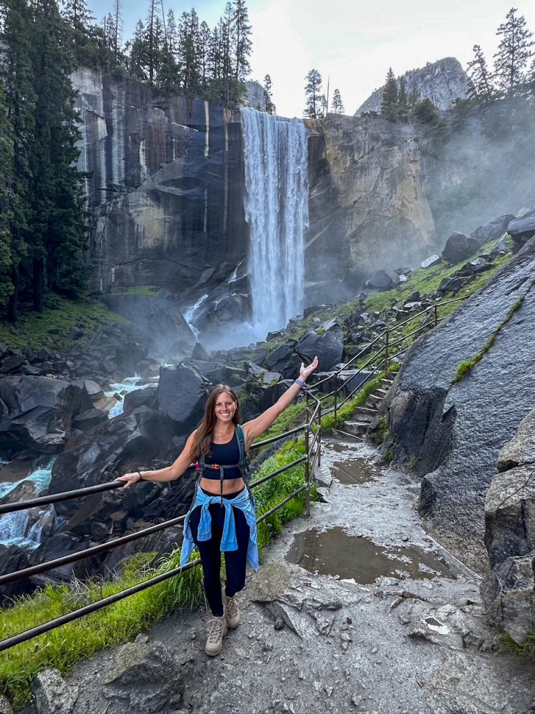 Sara presenting Vernal Fall at the bottom of some granite steps along the Mist Trail, the first hike on our 3-day Yosemite itinerary
