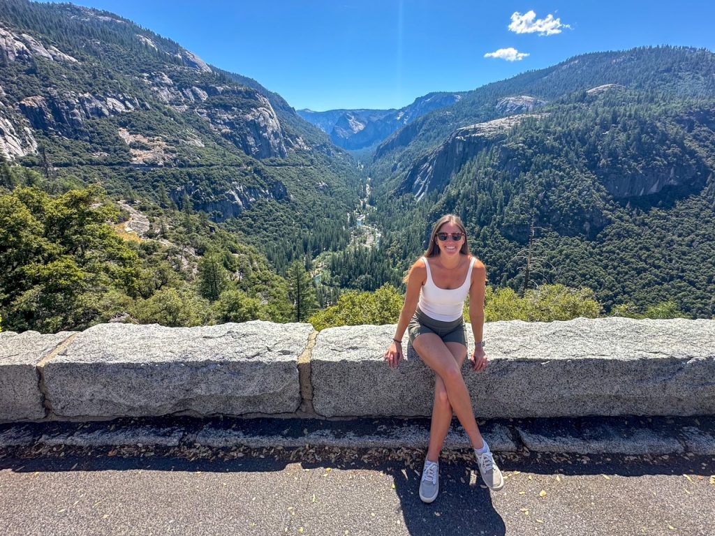 Sara sitting at an overlook with views of Yosemite Valley on the second day of our Yosemite itinerary