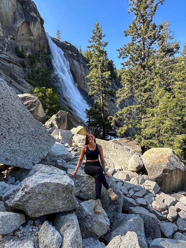Sara sitting on a rock in front of Nevada Fall on the Mist Trail in Yosemite