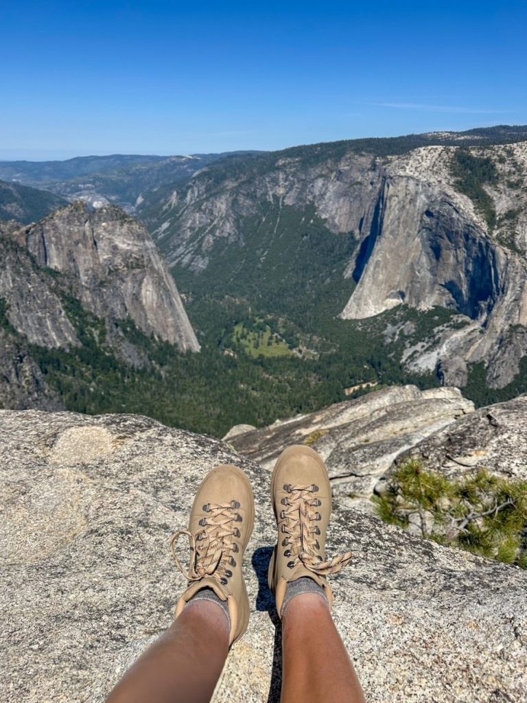 Sara's hiking boots in front of the view of El Capitan and the Yosemite Valley from Taft Point, one of the lower effort, high reward hikes in Yosemite