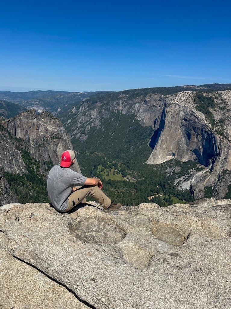 Tim sitting and admiring El Capitan at Taft Point in Yosemite