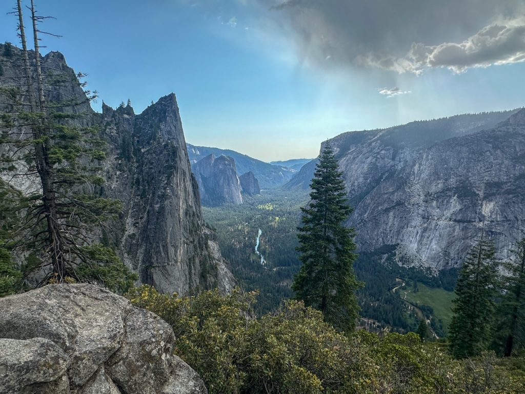 Yosemite Valley and Cathedral Rocks with a dark cloud overhead as seen from the Four Mile Trail, the last section of the most epic hike in Yosemite