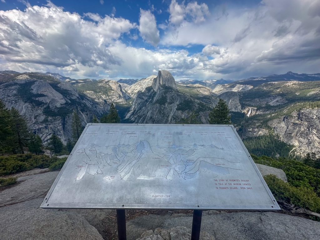 a sign and an incredible view behind it at Glacier Point in Yosemite National Park