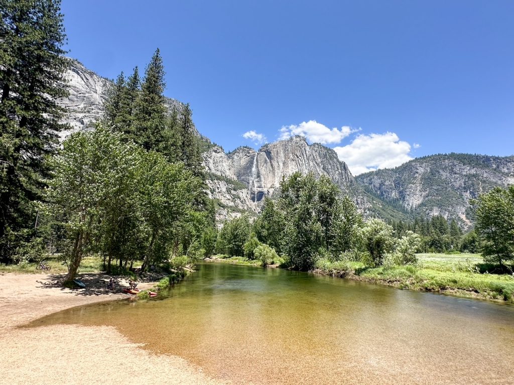 a stunning view of Yosemite Falls and the Merced River from Swinging Bridge in Yosemite