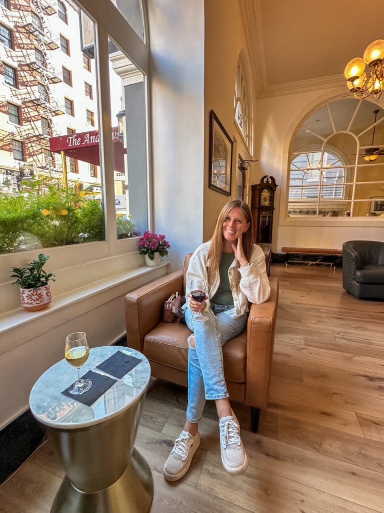 Guest enjoying complimentary wine at The Andrews Hotel in San Francisco after a day of exploring