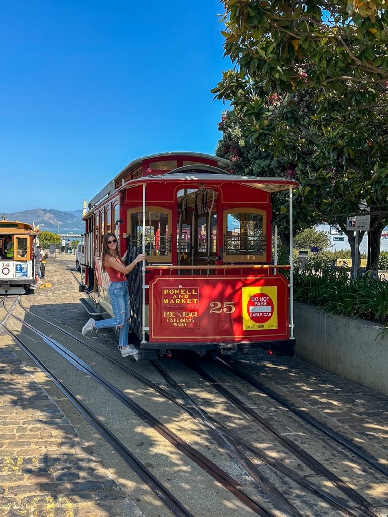 Traveler riding a historic cable car near Fisherman’s Wharf in San Francisco during a California road trip