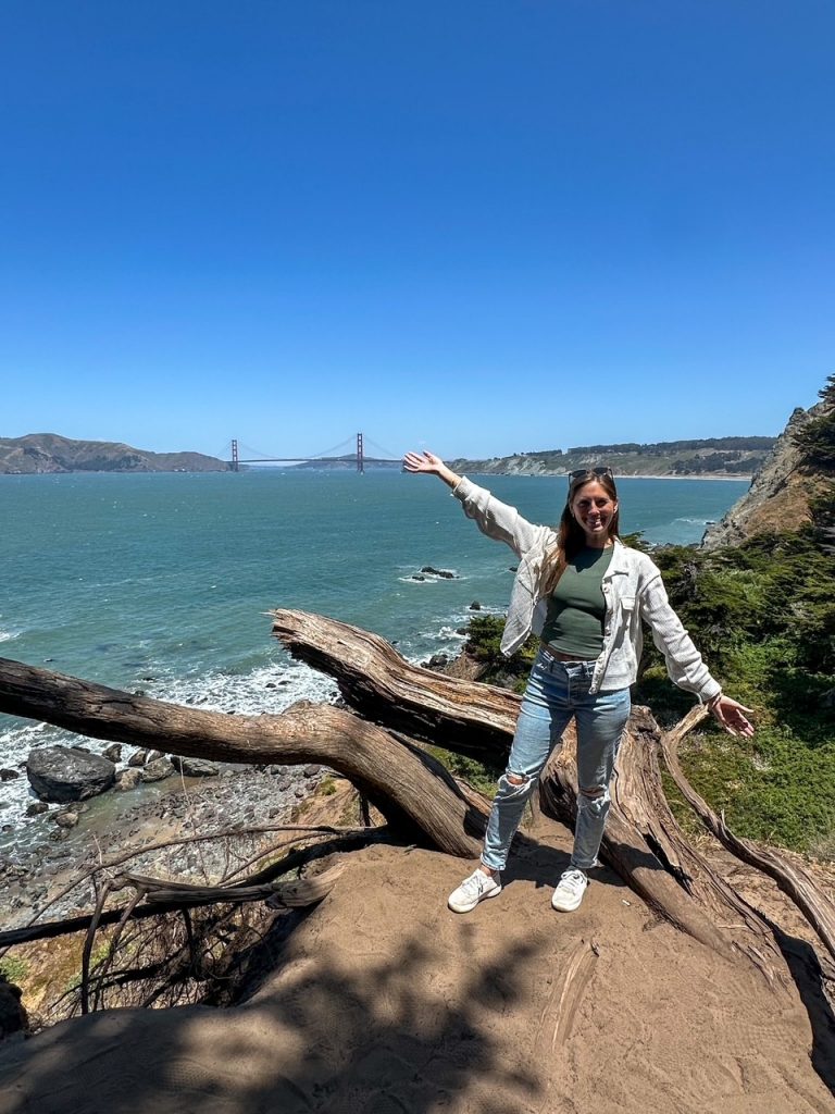 Sara posing in front of the Golden Gate Bridge on the Lands End Trail, a must-do during your 3 days in San Francisco