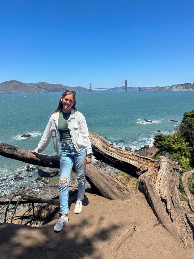 Sara in front of the Pacific Ocean and the Golden Gate Bridge on the Lands End Trail in San Francisco
