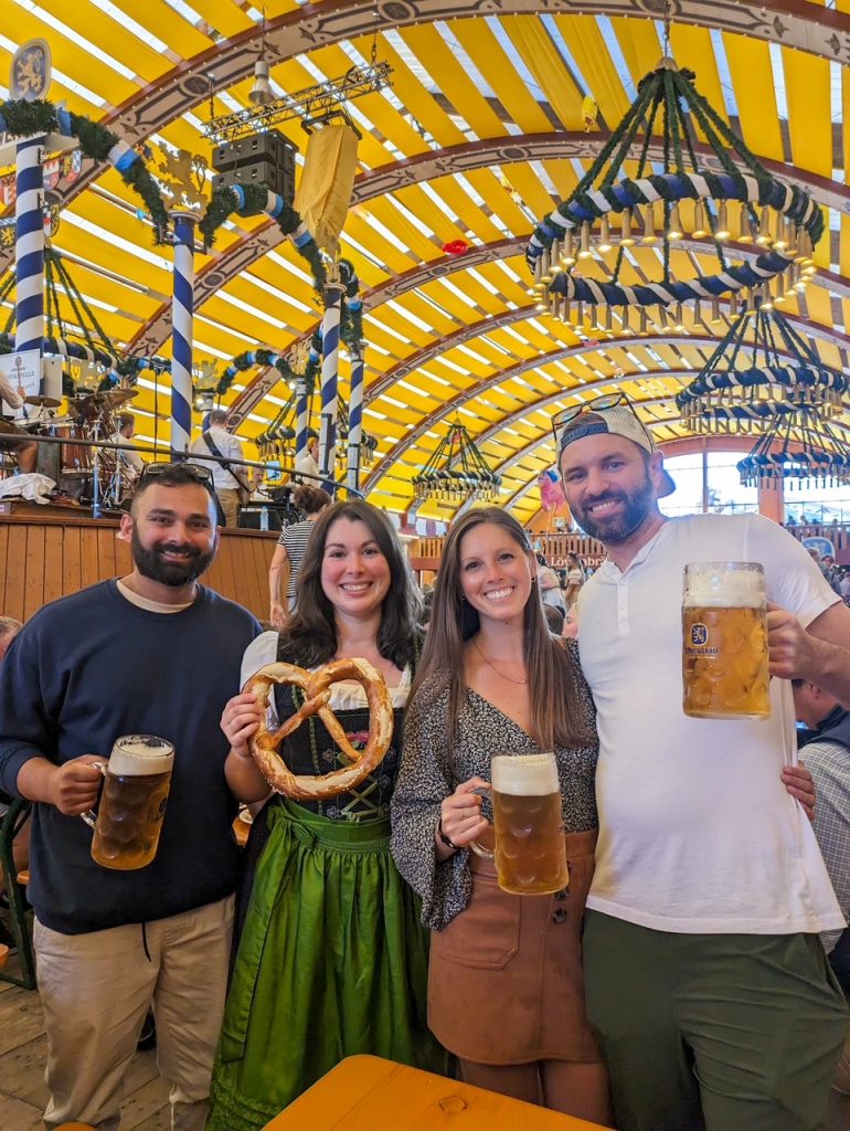 Couples with their beers and big pretzel at Oktoberfest in Munich