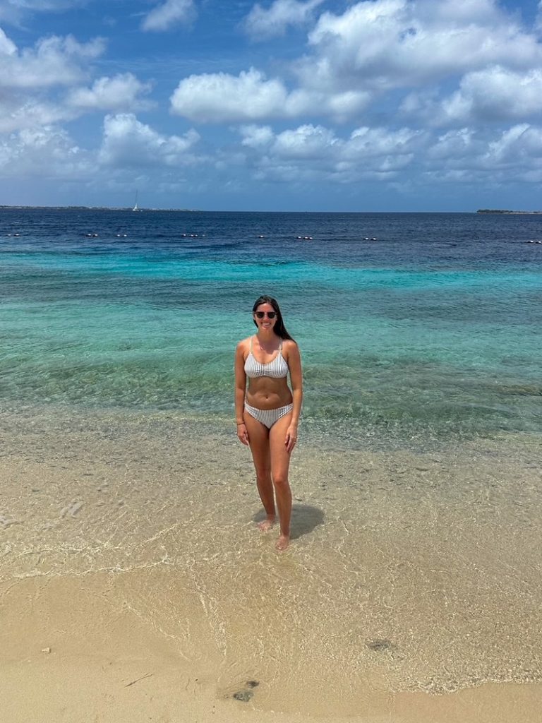 Sara standing in turquoise water before snorkeling in Bonaire