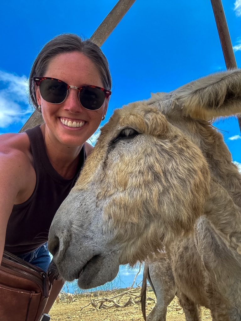 Sara taking a selfie with a donkey at the Donkey Sanctuary Bonaire