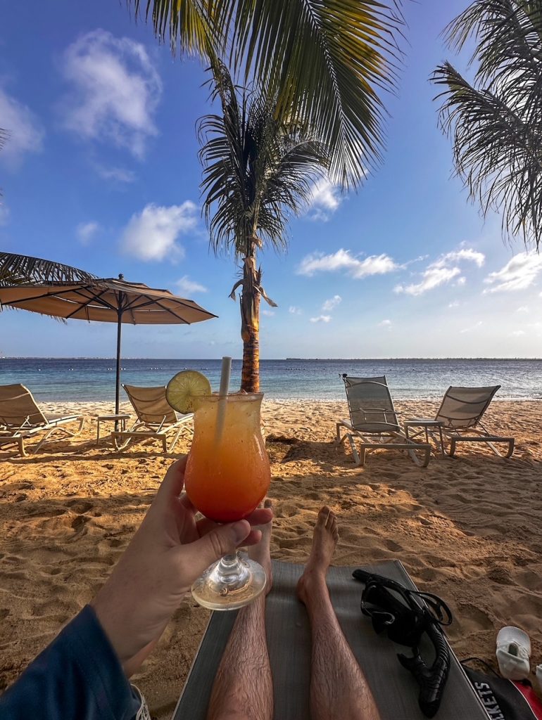 Tim with a drink on the beach at Harbour Village