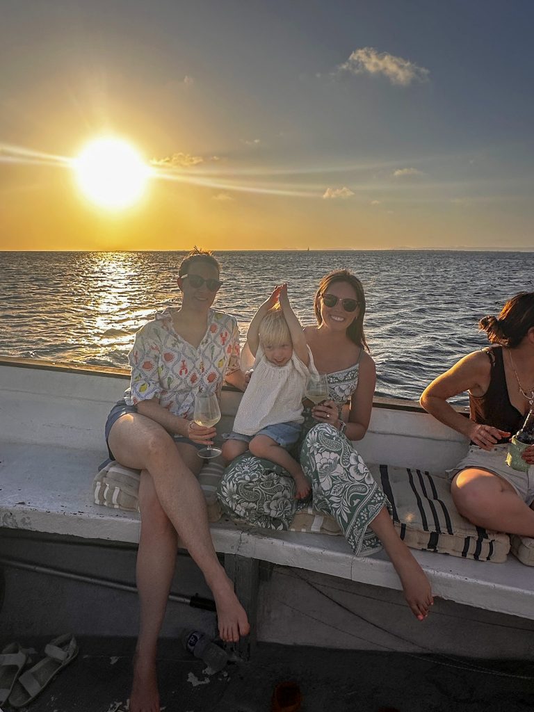 Friends and a toddler enjoying a sunset on a Bonaire boat tour